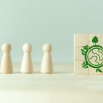 four wooden pawns next to green graphic of a environmental scene